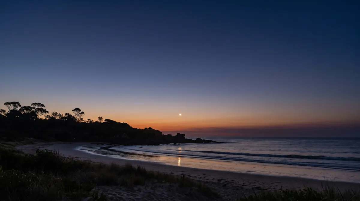 Brilliant Venus shining low in a deep twilight sky above a calm Australian beach with silhouetted headland, photorealistic evening scene.